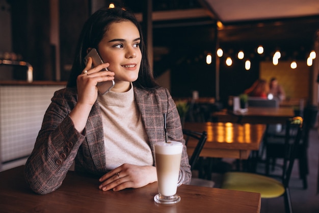 Frau mit Telefon und Kaffee in einem Café