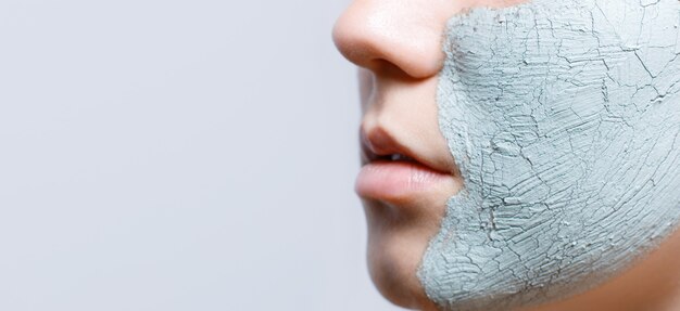 Frau mit Ton-Gesichtsmaske zur Hautpflege