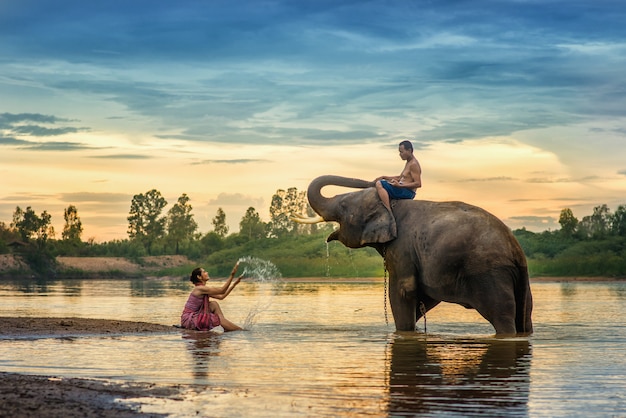 Frau mit traditionellem thailändischem Kleid umarmt ihren Elefanten am Elefantendorf, Surin, Thailand