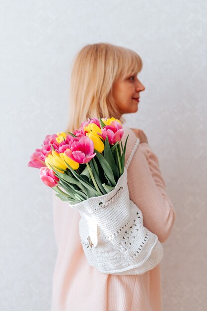 Frau mit Tüte Tulpenblumen