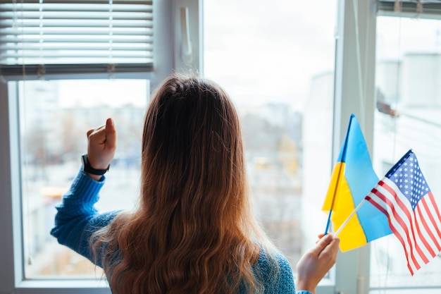 Frau mit ukrainischen und amerikanischen Flaggen während des Krieges mit russischer Invasion in der Ukraine Russischer Angriff