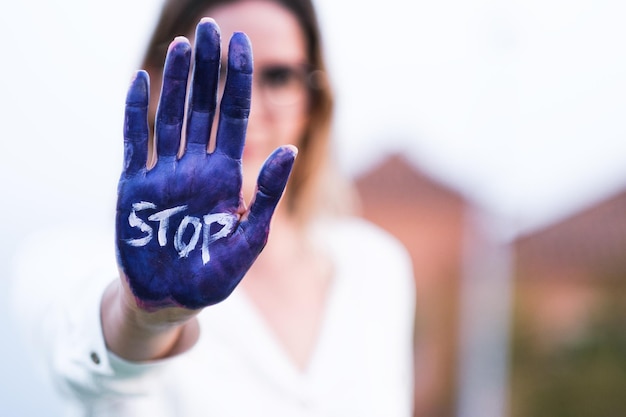 Foto frau mit unfokussiertem gesicht und händen, die vom feminismus bemalt sind