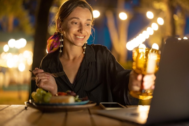 Frau mit Videoanruf und Toasten auf Laptop