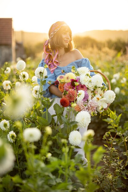 Frau mit vielen Blumen auf Dahlienfarm im Freien