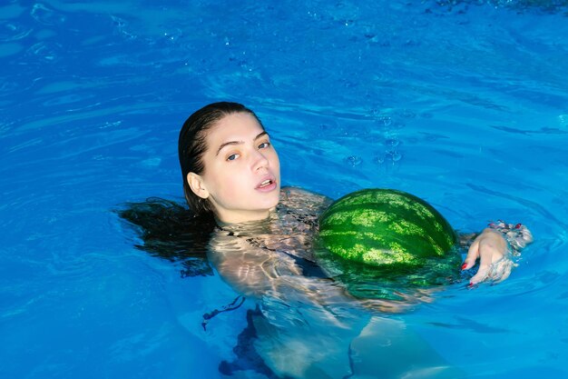 Frau mit Wassermelone im Schwimmbad