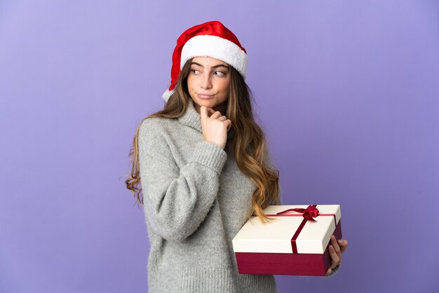 Frau mit Weihnachtsmütze hält Geschenke