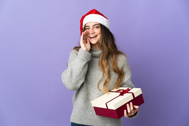 Frau mit Weihnachtsmütze hält Geschenke