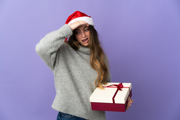 Frau mit Weihnachtsmütze hält Geschenke