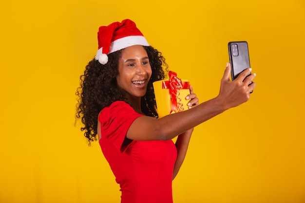 Frau mit Weihnachtsmütze und Selfie mit Geschenkbox