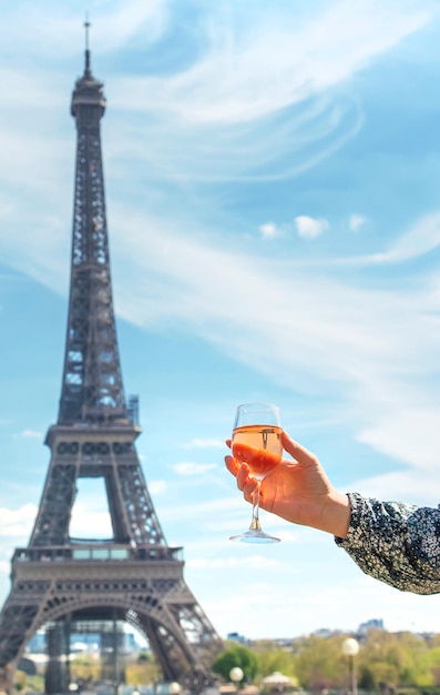 Frau mit Wein in der Nähe des Eiffelturms Selektiver Fokus