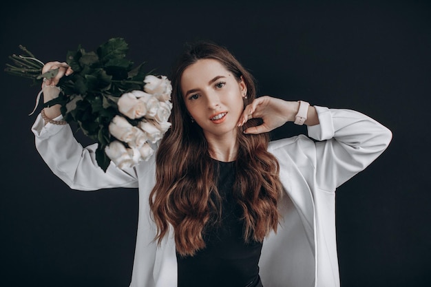 Frau mit weißen Rosen auf schwarzem Hintergrund