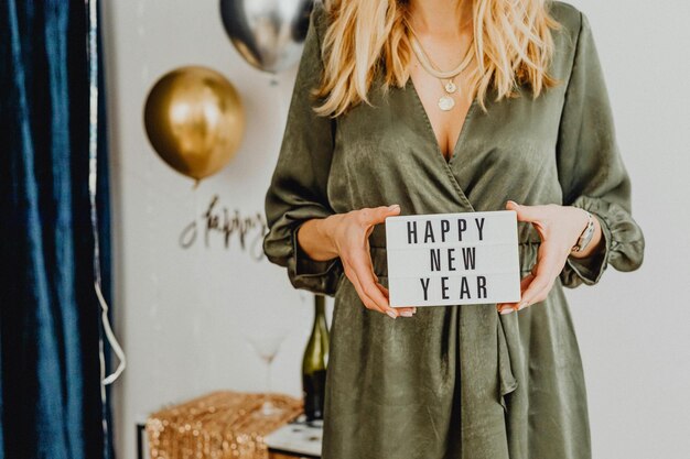 Frau mit weißer Karte mit frohem Neujahr Text Stock Photo