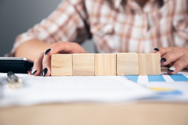 Frau mit Würfeln auf Arbeitsdokumenten