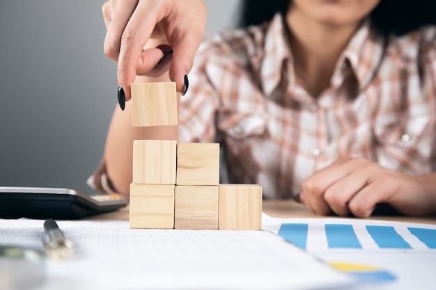 Frau mit Würfeln auf Arbeitsdokumenten