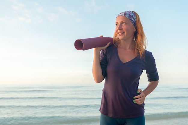 Frau mit Yogamatte