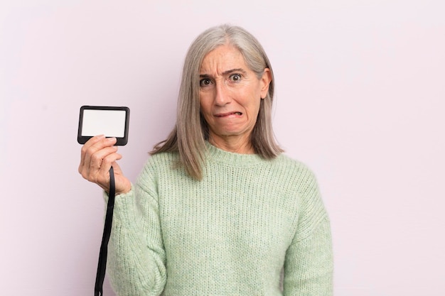 Frau mittleren alters, die verwirrt und verwirrt aussieht vip-pass-konzept