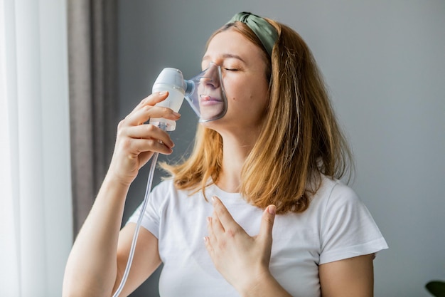 Frau mittleren Alters macht Inhalation zu Hause Kalte Atemwegserkrankungen Influenza und Virusinfektion