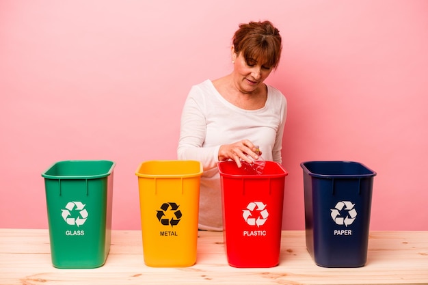 Frau mittleren Alters Recycling isoliert auf rosa Hintergrund