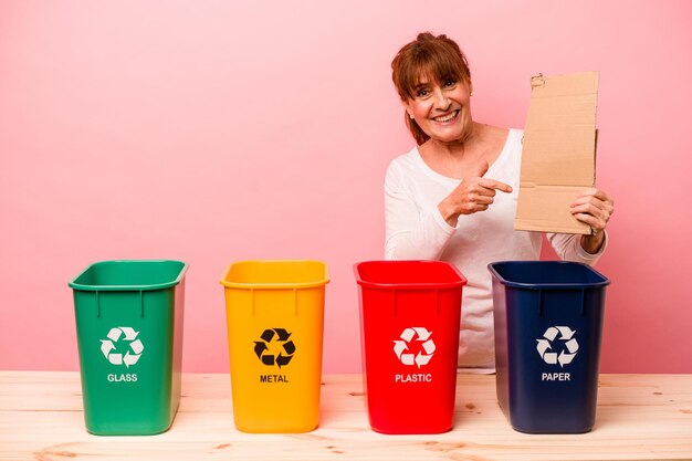 Frau mittleren Alters Recycling isoliert auf rosa Hintergrund