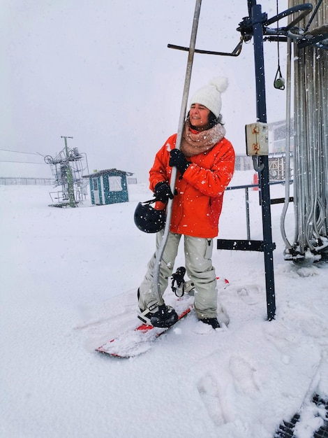 Frau mittleren Alters Snowboarden auf einer Skipiste