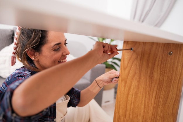 Frau montiert ein Möbelstück für ihr Zuhause Konzept selbstversorgendes Tischlerhandwerk