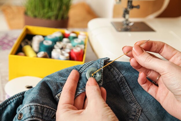 Frau Nähen auf Knopf Fadennadel Nähen Knopf Jeans Nahaufnahme Authentischer Lebensstil Handgemacht