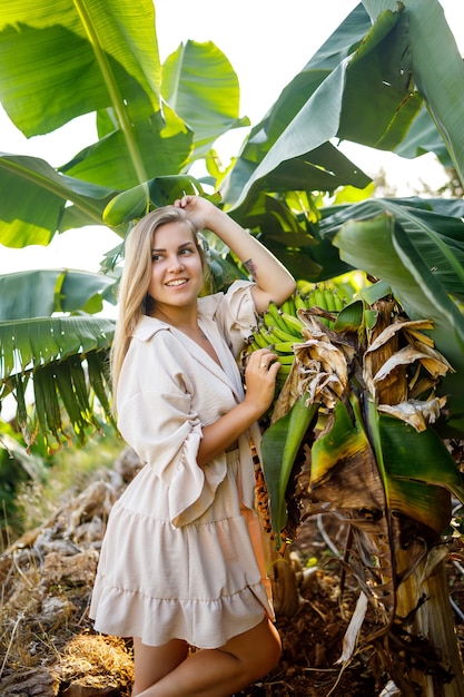 Frau nahe großem grünem Blatt des Bananenbaums auf Natur im Park Tropische Pflanzen