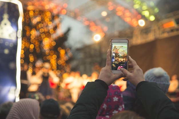 Frau nimmt Konzert auf ihrem Handy auf