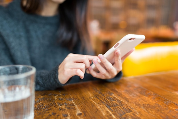 Frau nutzt Handy im Café