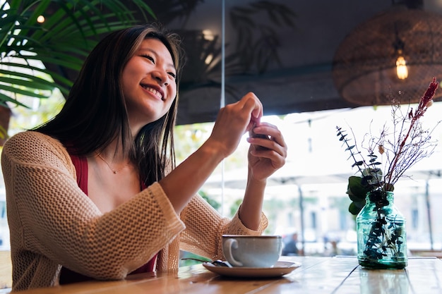 Frau öffnet den Zuckerbeutel für ihren Kaffee