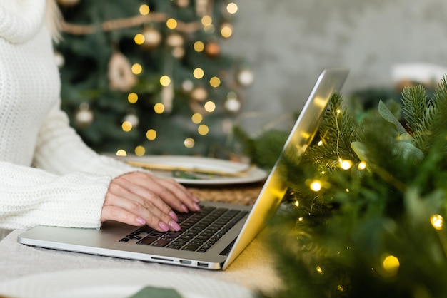 Frau online mit laptop zu hause im wohnzimmer.