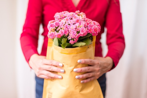 Frau pass Blumen in Blase Paddel Mailer Umschlag