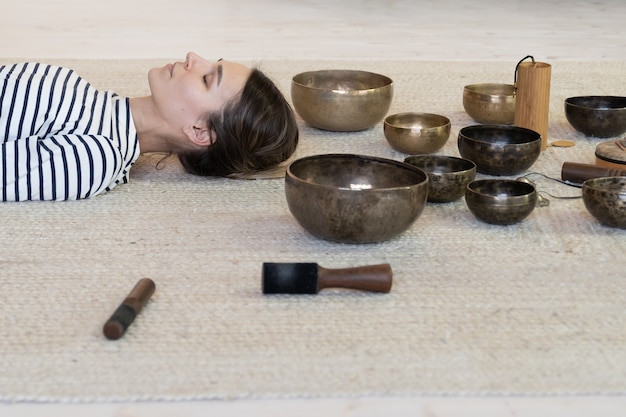 Frau praktiziert Meditation mit tibetischen Klangschalen Therapie weibliche Meditation von Klangmassage sound