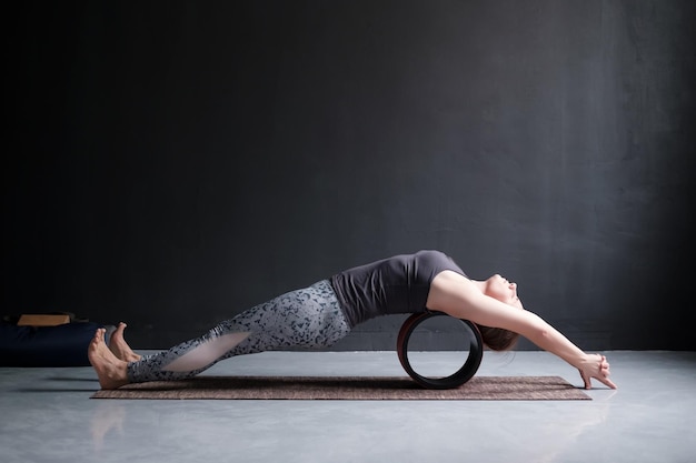 Frau praktiziert Yoga Asana Matsyasana-Fischhaltung