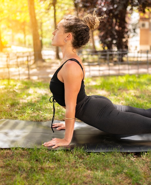 Frau praktiziert Yoga-Pose im Freien