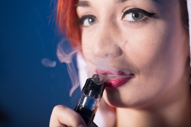 Frau raucht elektronische Zigarette und Ausatmen von Rauch Nahaufnahme