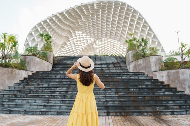 Frau Reisende mit gelbem Kleid zu Besuch in der Stadt Da Nang Touristische Besichtigung des Stadtgebäudes Wahrzeichen und beliebt für Touristenattraktion Vietnam und Südostasien Reisekonzept