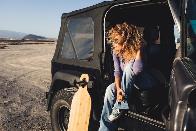 Frau reist allein mit schwarzem Auto und langem Brettertisch
