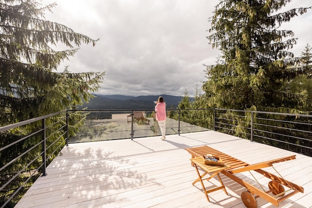 Frau ruht auf der Terrasse in den Bergen