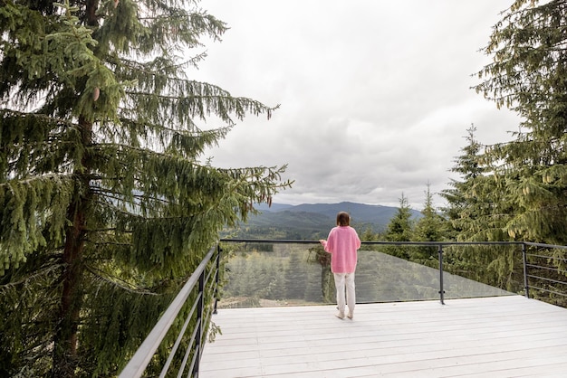 Frau ruht auf der Terrasse in den Bergen