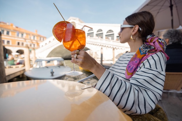 Frau ruht sich im Café im Freien am Canal Grande aus, das Venedig bereist