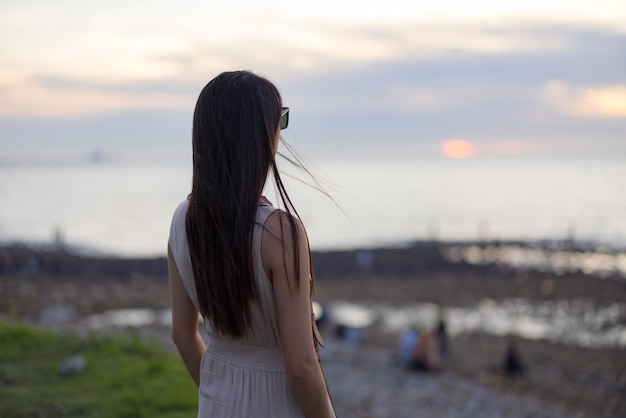 Frau schaut auf das Meer in Bali von Taiwan bei Sonnenuntergang