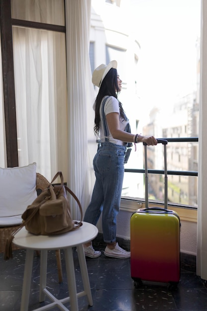 Foto frau schaut aus einem hotelfenster