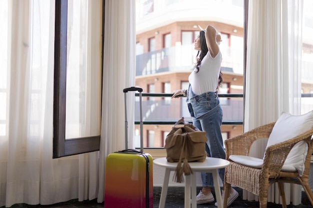 Foto frau schaut aus einem hotelfenster