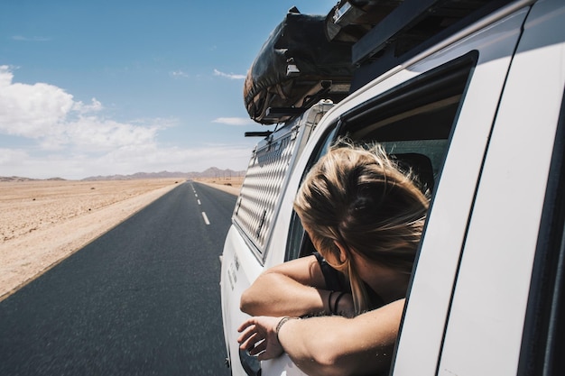 Foto frau schaut durch das autofenster gegen den himmel