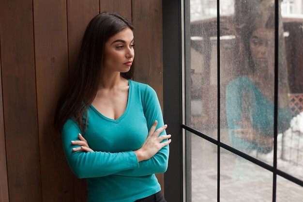 Frau schaut durch das Fenster