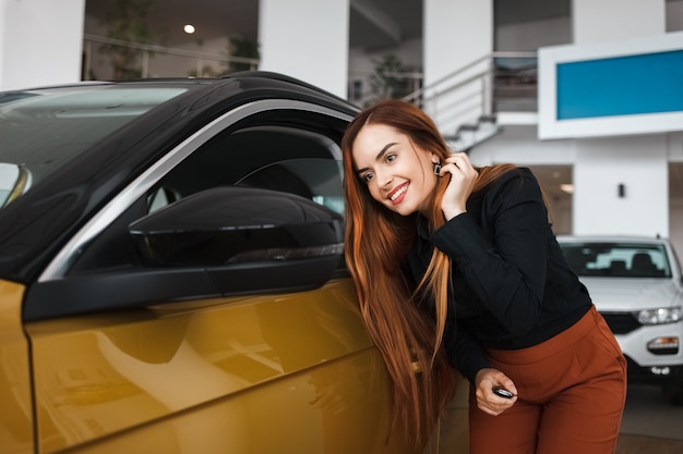 Frau schaut in den Spiegel eines Autos