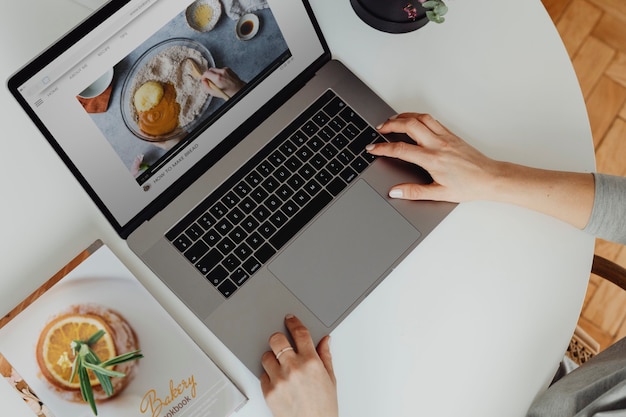 Frau schaut sich Backrezepte auf ihrem Laptop an