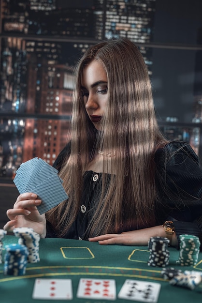 Frau schaut sich Pokerkarten am Casino-Tisch und Chips an. Glück und Reichtum