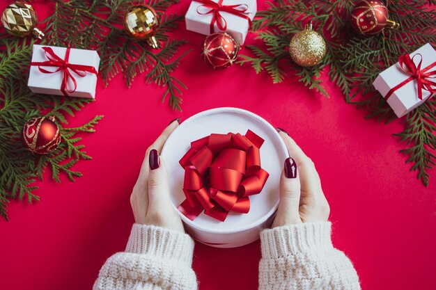 Frau schenkt schöne Geschenkkiste mit rotem Bogen Weihnachtskonzept